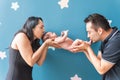 latin mother and father hold their baby in their hands giving him a kiss on a blue wall with stars Royalty Free Stock Photo