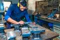 A Latin operator making measurements with the caliper on a milling cutter Royalty Free Stock Photo