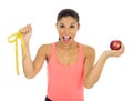 Latin sport woman in fitness clothes holding apple fruit and m Royalty Free Stock Photo