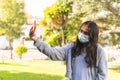 Latin teen girl with surgical mask taking a selfie with her cell phone in a park Royalty Free Stock Photo