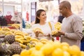 Latin american woman choosing ripe bananas in supermarket with his boyfriend Royalty Free Stock Photo