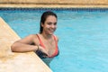 Woman in bikini relaxing at sunny summer poolside