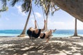 Latin woman on black bikini, swinging in Caribbean beach, wooden swing, awesome lifestyle postcard