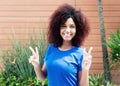 Latin woman in blue shirt showing victory sign