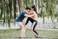 Latin woman and Caucasian shadow do yoga exercises in a park in Madrid. Balance and concentration in couple