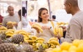 Latin woman choosing ripe bananas in supermarket with his boyfriend Royalty Free Stock Photo