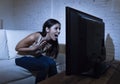 Latin woman home watching television close distance excited in TV addiction concept