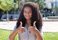 Latin woman with long curly hair showing both thumbs up Royalty Free Stock Photo