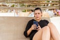 latin woman lying on a bed at the beach chatting on cell phone Royalty Free Stock Photo