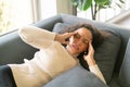 Latin woman lying down on sofa with headache feeling Royalty Free Stock Photo