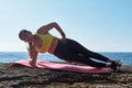 Latin woman, middle-aged, wearing sportswear, training, doing physical exercises, plank, sit-ups, climber`s step, burning calorie Royalty Free Stock Photo