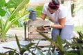 Latin woman painting chair at home. A female is upcycling a wooden seat, She is kneeling on the floor Royalty Free Stock Photo