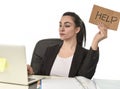 Latin woman showing help sign desperate suffering stress at work while sitting at office laptop Royalty Free Stock Photo