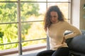 Latin woman sitting on sofa with backache feeling Royalty Free Stock Photo