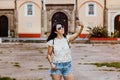 Latin woman in summer sun glasses and holding a smart phone taking a photo in Mexico City, tourist Mexican girl