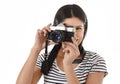 Latin woman taking pictures looking through the viewfinder of an old cool retro vintage photo camera Royalty Free Stock Photo