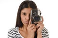 Latin woman taking pictures looking through the viewfinder of an old cool retro vintage photo camera Royalty Free Stock Photo