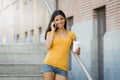 Latin woman talking on her mobile phone while drinking coffee Royalty Free Stock Photo