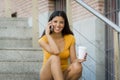 Latin woman talking on her mobile phone while drinking coffee Royalty Free Stock Photo