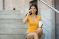 Latin woman talking on her mobile phone while drinking coffee Royalty Free Stock Photo