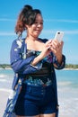 Woman Using her smartphone at the beach Royalty Free Stock Photo