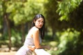 Latin woman, young and beautiful brunette leaning over the railing of a wooden bridge. The woman looks sad and nostalgic and is Royalty Free Stock Photo