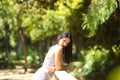 Latin woman, young and beautiful brunette leaning over the railing of a wooden bridge. The woman looks sad and nostalgic and is Royalty Free Stock Photo