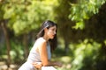 Latin woman, young and beautiful brunette leaning over the railing of a wooden bridge. The woman looks sad and nostalgic and is Royalty Free Stock Photo