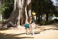 Latin women couple, young, dancing bachata with a big tree in the background in an outdoor park, performing different dance Royalty Free Stock Photo