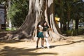 Latin women couple, young, dancing bachata with a big tree in the background in an outdoor park, performing different dance Royalty Free Stock Photo