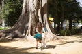 Latin women couple, young, dancing bachata with a big tree in the background in an outdoor park, performing different dance Royalty Free Stock Photo