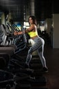 Latin Women On Elliptical Treadmill In Fitness Gym