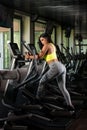 Latin Women On Elliptical Treadmill In Fitness Gym