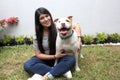 Latin young adult woman with long straight black hair is very happy accompanied by her friend a white pitbull dog with brown spots