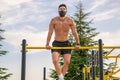 Strong young latin man doing calisthenics with mask