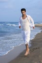 Latin young man white shirt walking blue beach Royalty Free Stock Photo