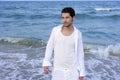 Latin young man white shirt walking blue beach Royalty Free Stock Photo