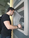 Latin young man withdrawing money from a cashpoint machine