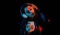 Latin young woman with headphones listening to music over color neon and black background in Mexico Latin America