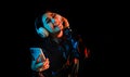 Latin young woman with headphones listening to music over color neon and black background in Mexico Latin America