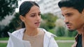 Latina couple reading documents outdoors closeup. Serious coworkers working park