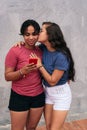 Latina couple takes selfie and smiles. Woman kissing her partner with a cell phone