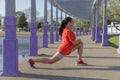 Latina girl with a red t-shirt stretching in a pergola in a public park Royalty Free Stock Photo