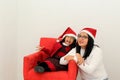 Latina mom and daughter with glasses hat and Christmas garland show their enthusiasm and happiness for the arrival of December and