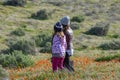 Latina Mother and Daughter walking in desert California Poppy field on path