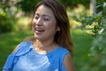 Latina Mother Smiling in Back Yard in front of red leaved bush Royalty Free Stock Photo