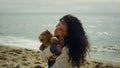 Latina woman posing sea beach. Gorgeous lady modeling holding teddy bear outside Royalty Free Stock Photo