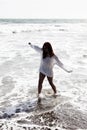 Latina Woman Walking In Ocean Water On Beach White Knit Covering