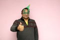 Latino adult man with Christmas hat, glasses and sweater shows his enthusiasm and happiness for the arrival of December and celebr