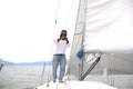 Latino adult man drives a sailboat on the lake with sails unfurled as a physical activity, sport and hobby to relax for the weeken